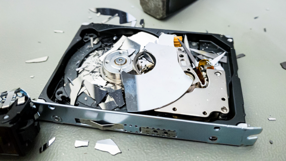 Ødelagt harddisk med knust platelager etter fysisk destruksjon av data