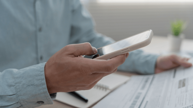 Person tar bilde av dokument med mobilen