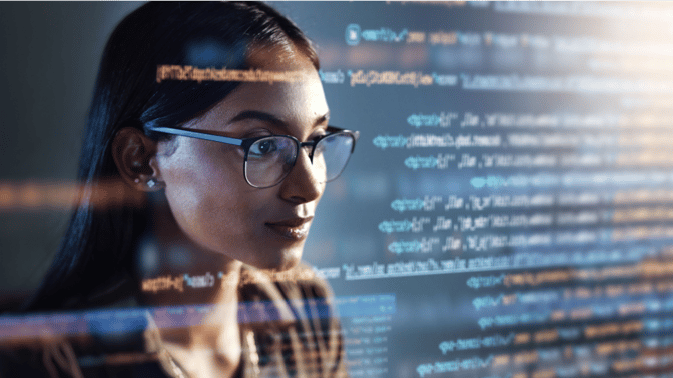 Kvinne ser på en skjerm med data og koder