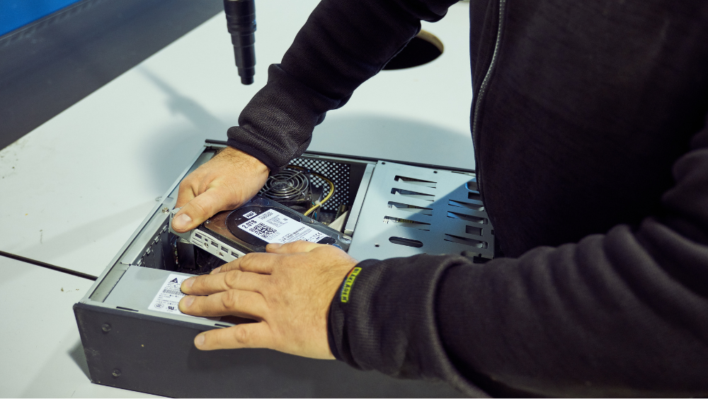 Ansatt fra NG Secure inspiserer bærbar PC før sikker datasletting